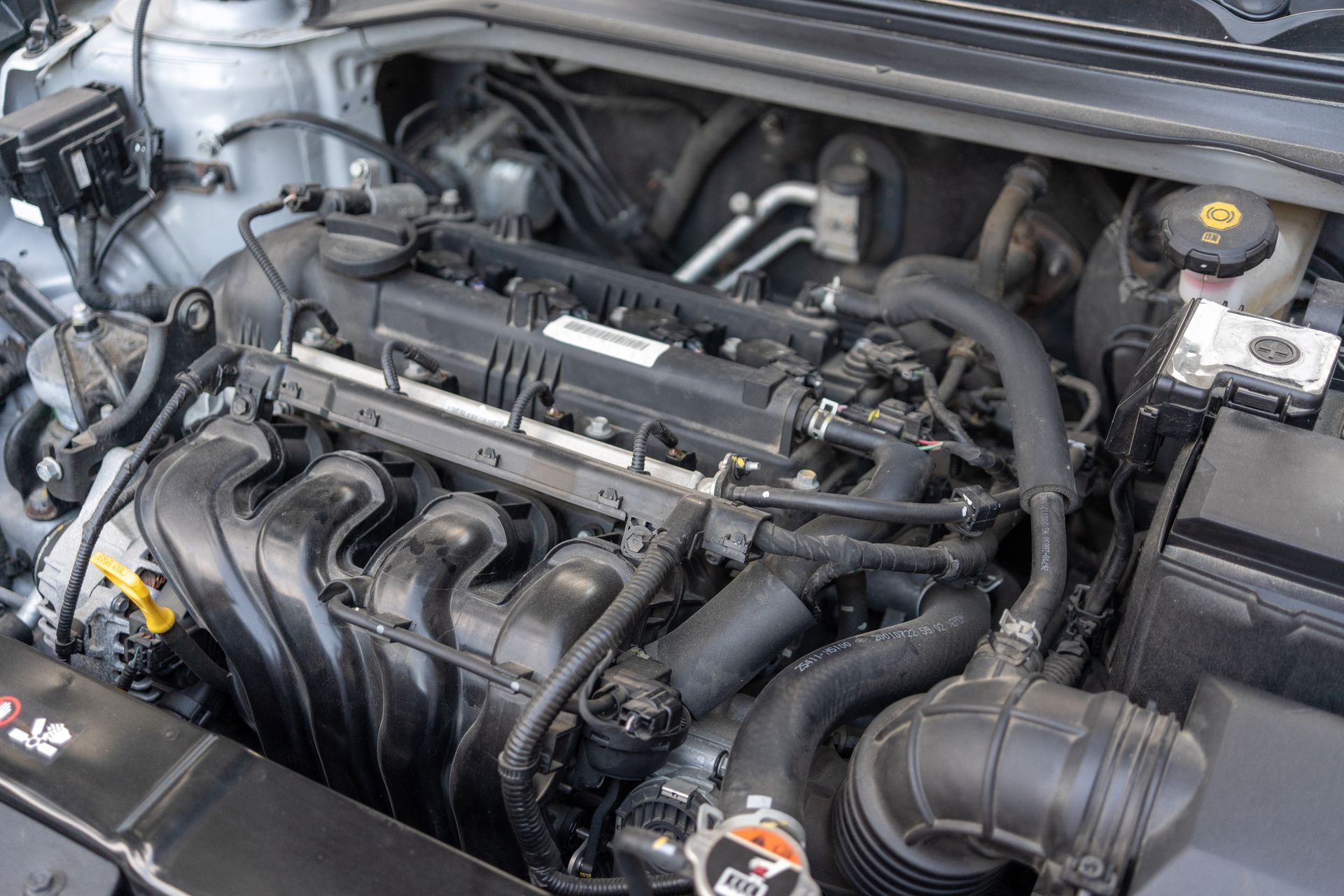 A close up of a car engine with the hood open.