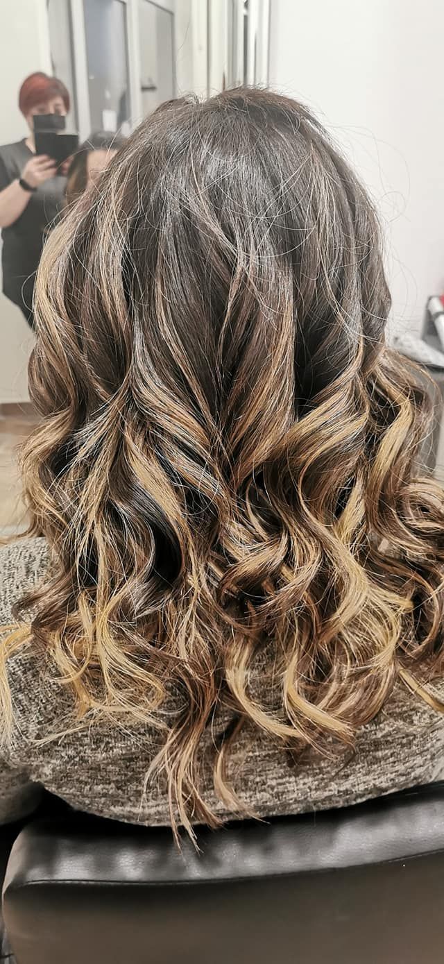 Una donna si sta facendo i capelli in un salone.