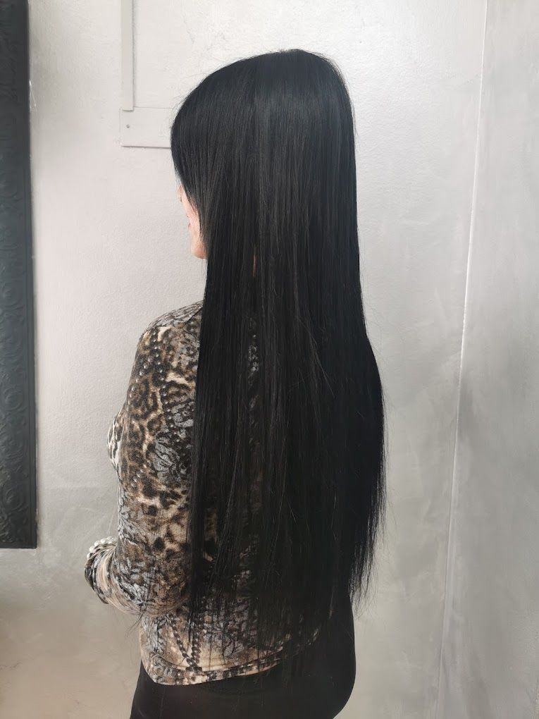 Una donna con lunghi capelli neri indossa una maglietta leopardata.