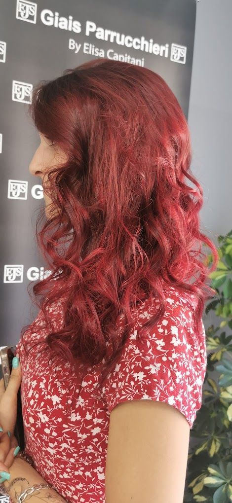 Una donna con i capelli rossi indossa una camicia rossa a fiori.