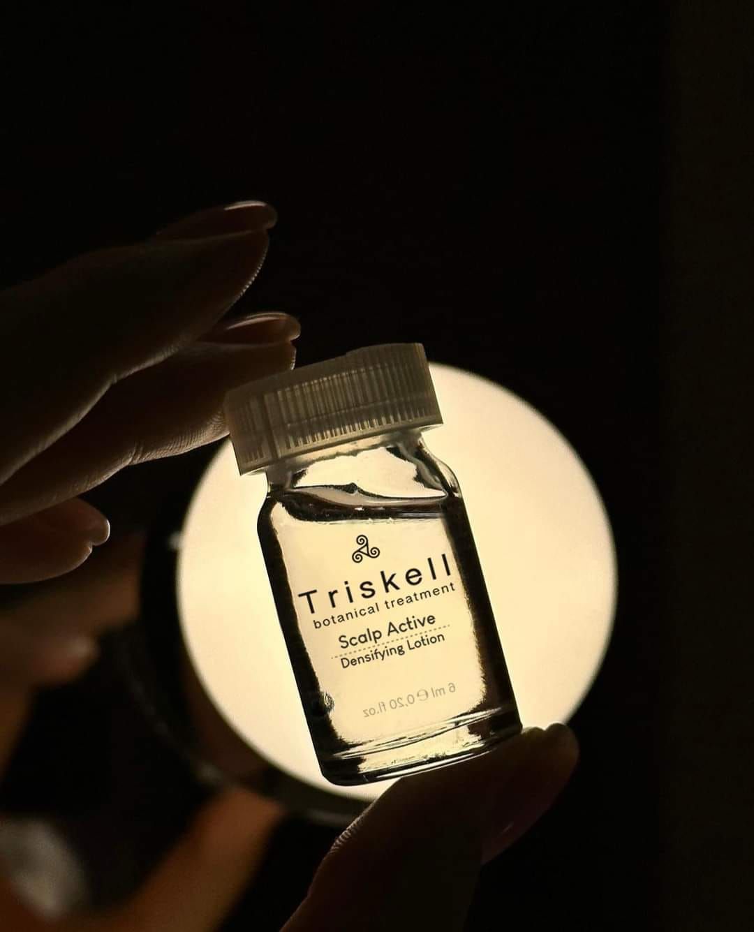 Una persona tiene in mano una bottiglia di siero Triskell