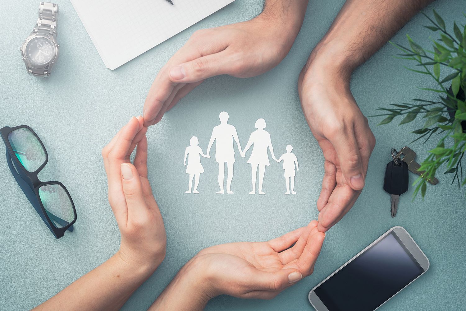 Hands forming a protective circle around a family silhouette, symbolizing protection.