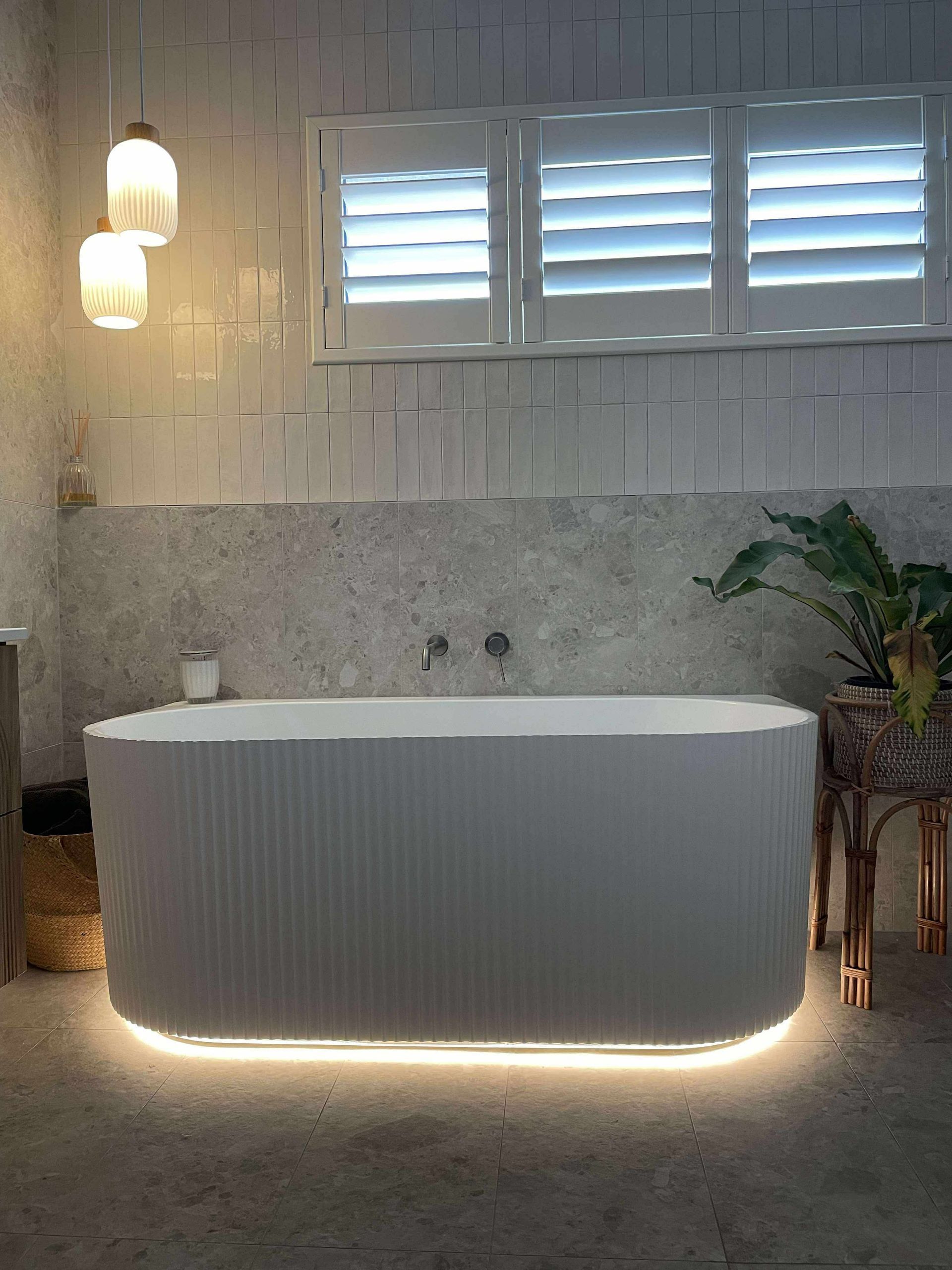 Bathroom with a white bathtub, accent lighting, shutters, pendant lights, and a plant — Stuart Pearce Electrical In Coffs Harbour, NSW
