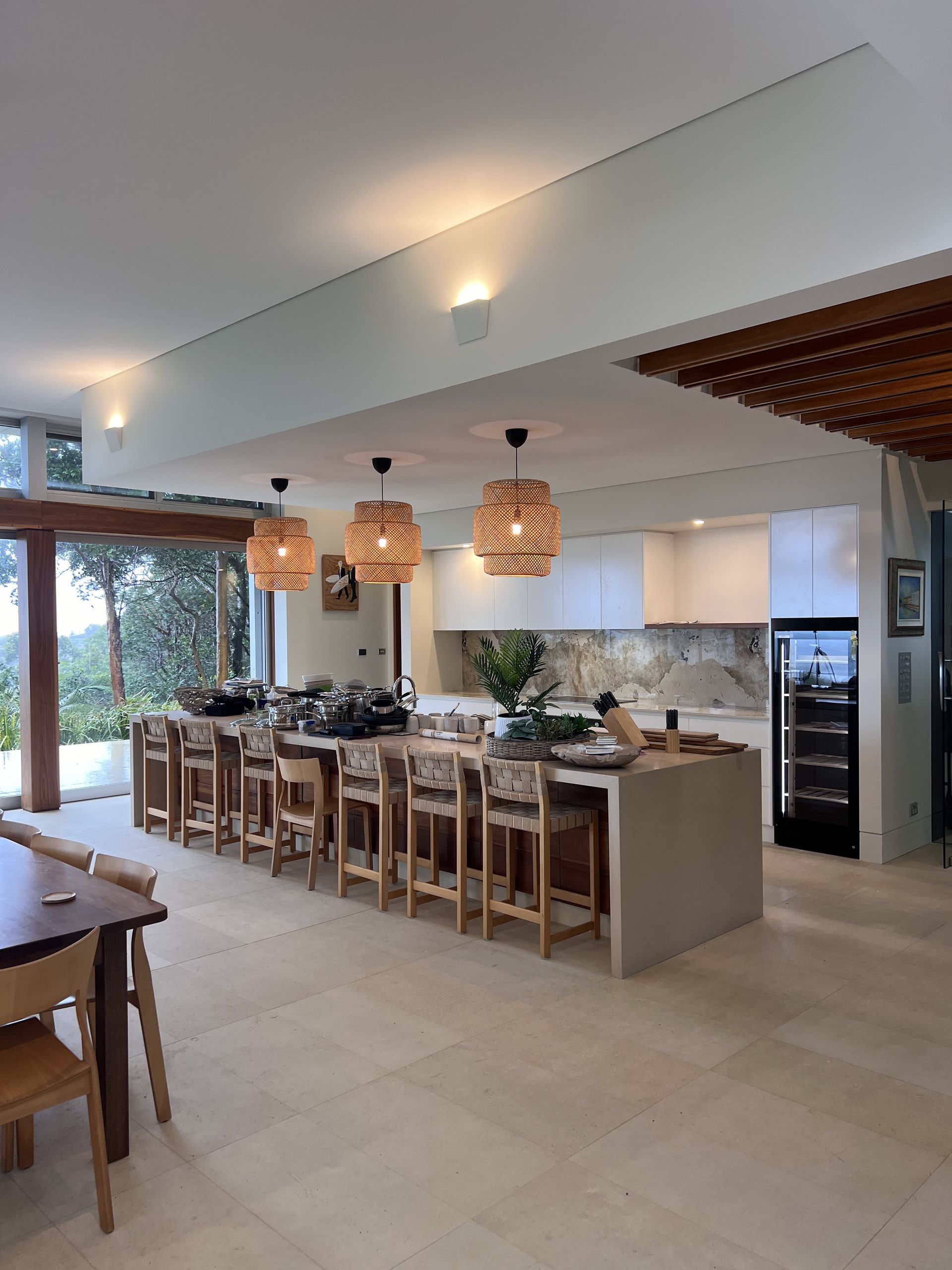 Modern kitchen with large island, pendant lights, bar stools, and built-in appliances — Stuart Pearce Electrical In Coffs Harbour, NSW