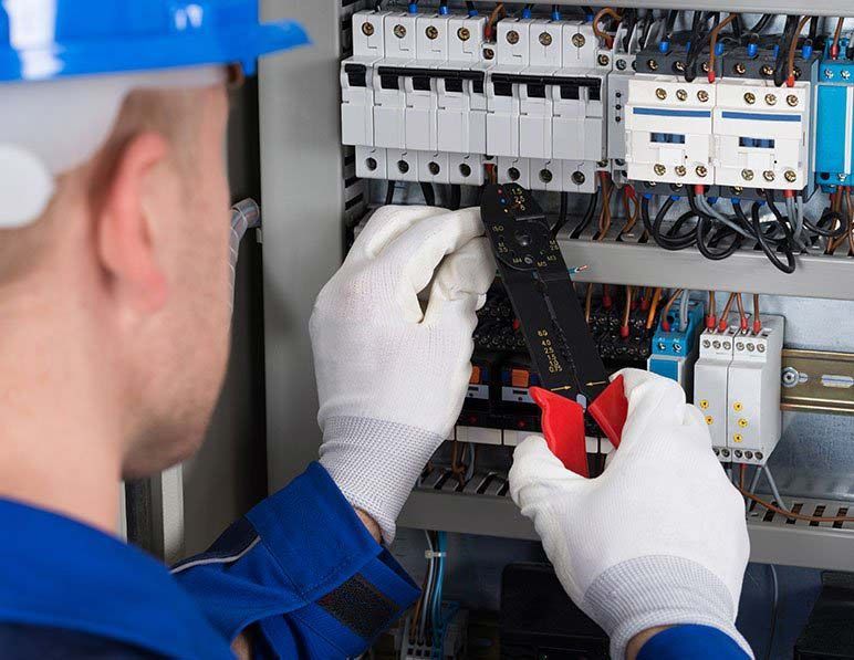 an electrician is working on an electrical panel .