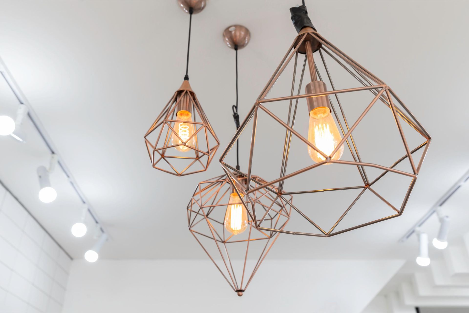 a group of copper pendant lights hanging from the ceiling .