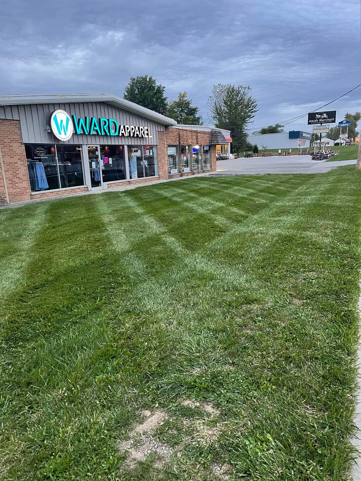 Green lawn in front of Ward's apparel store with cloudy sky.