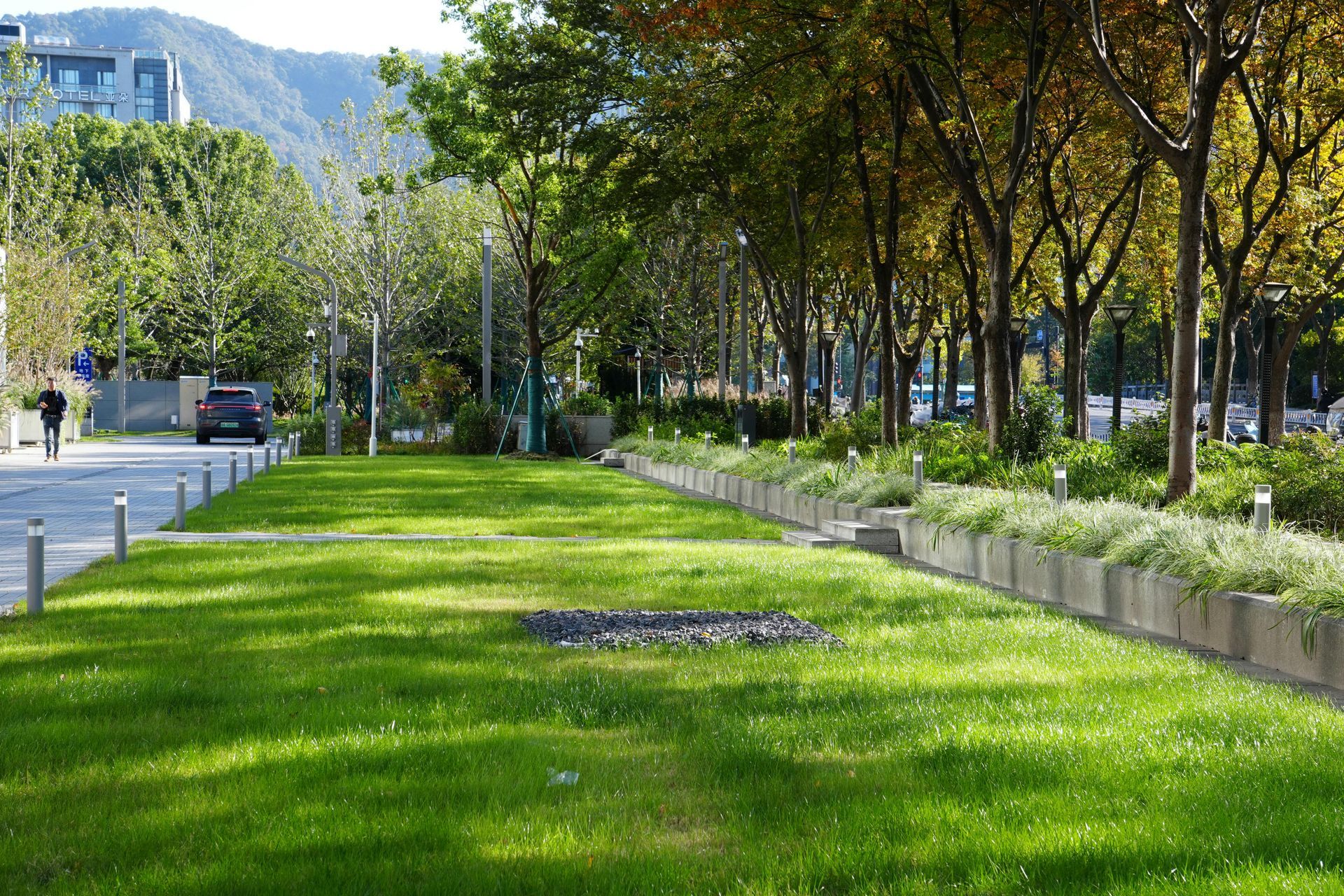 Front yard flower bed with pink azaleas beside a house and driveway