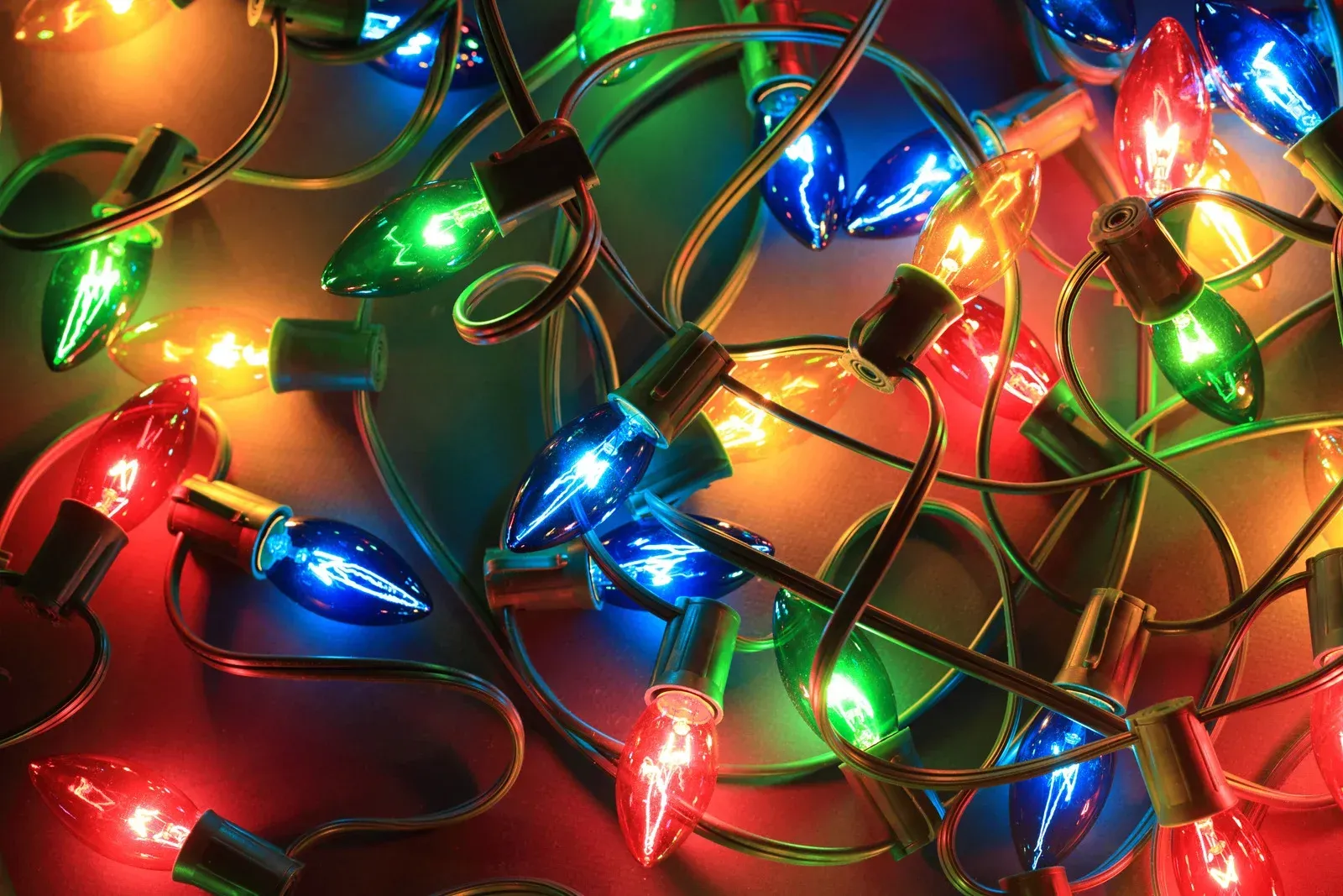 Colorful Christmas lights, tangled, in various colors: red, green, blue, orange.