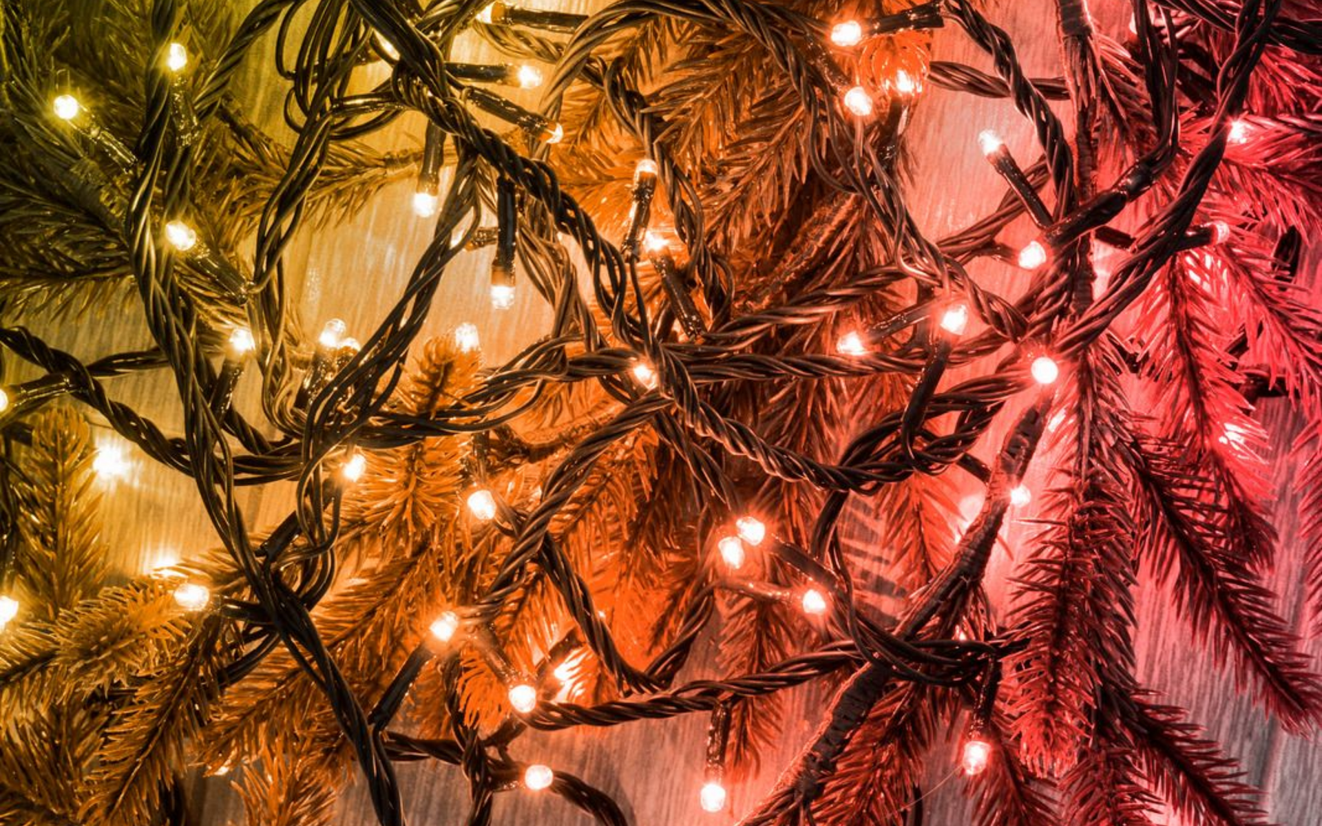 A two-story brick house with a shingled roof, surrounded by a manicured lawn and trees under a clear blue sky.