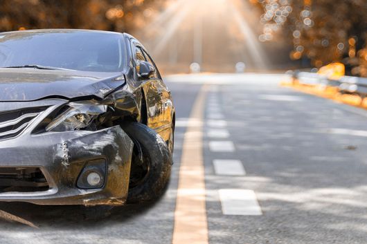 A damaged car is parked on the side of the road.