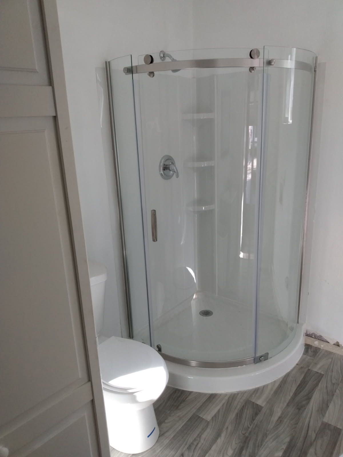 A bathroom with a toilet and a shower stall.