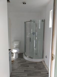 A bathroom with a toilet and a shower stall.