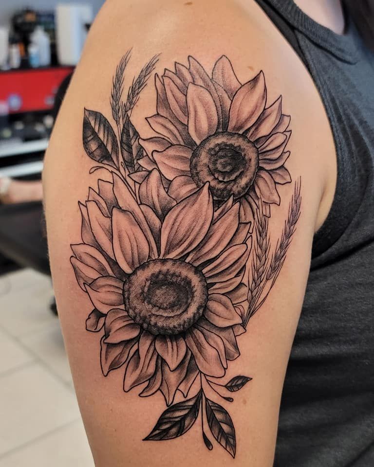 A woman has a tattoo of sunflowers on her shoulder.