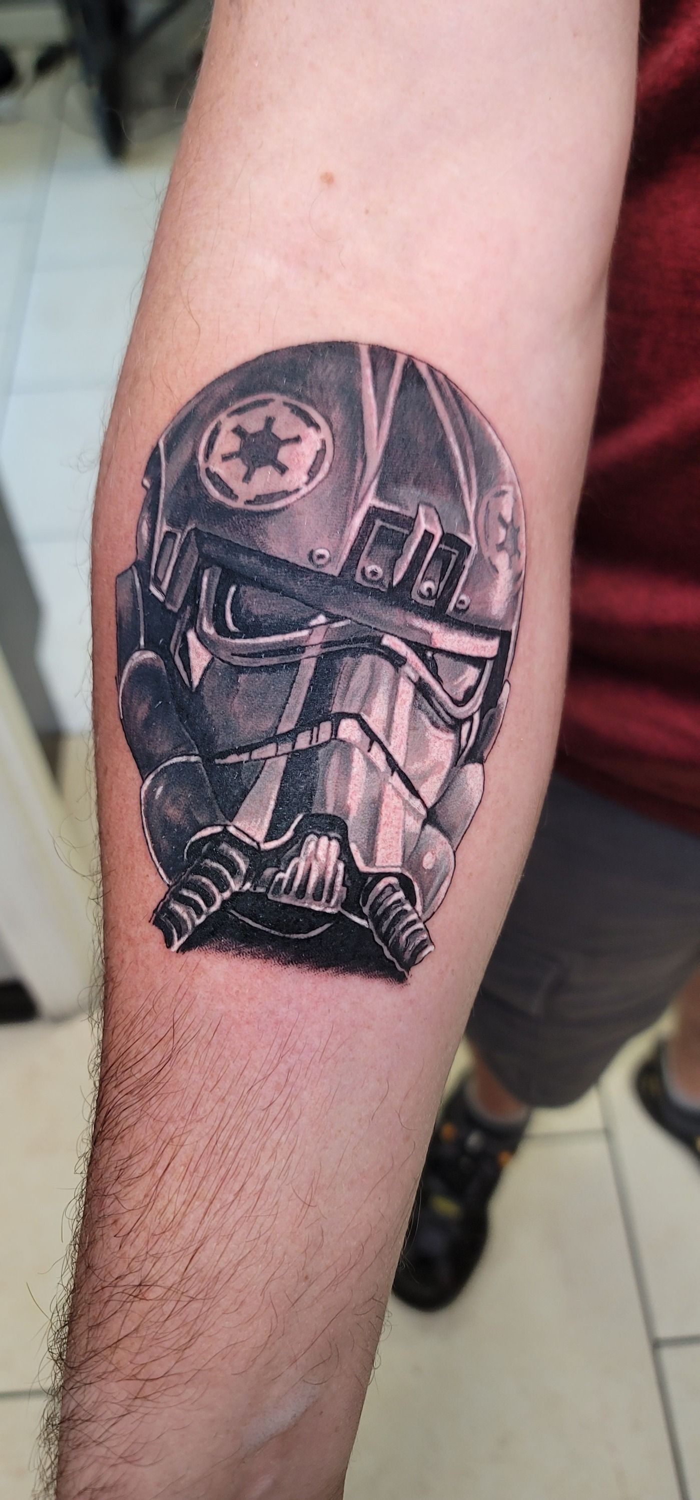 A man has a tattoo of a storm trooper on his arm.
