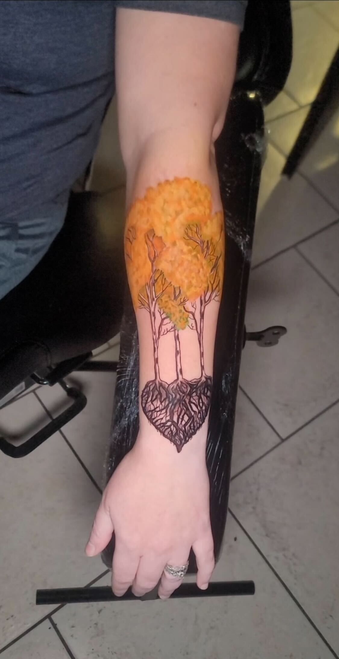 A person has a tattoo on their arm that looks like a tree.