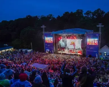 Top Tip: Arrive early to explore the stunning surroundings of Scarborough and grab a spot with the best view of the sea before the performance starts! View of Scarborough Open Air Theatre, showcasing an outdoor performance under the open sky.