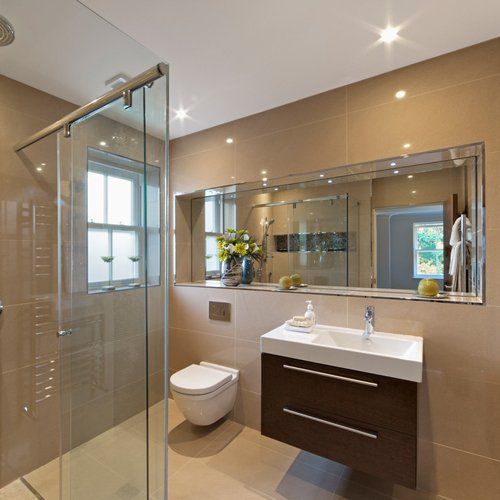 A modern bathroom with a glass shower cubicle and mirrors on the wall
