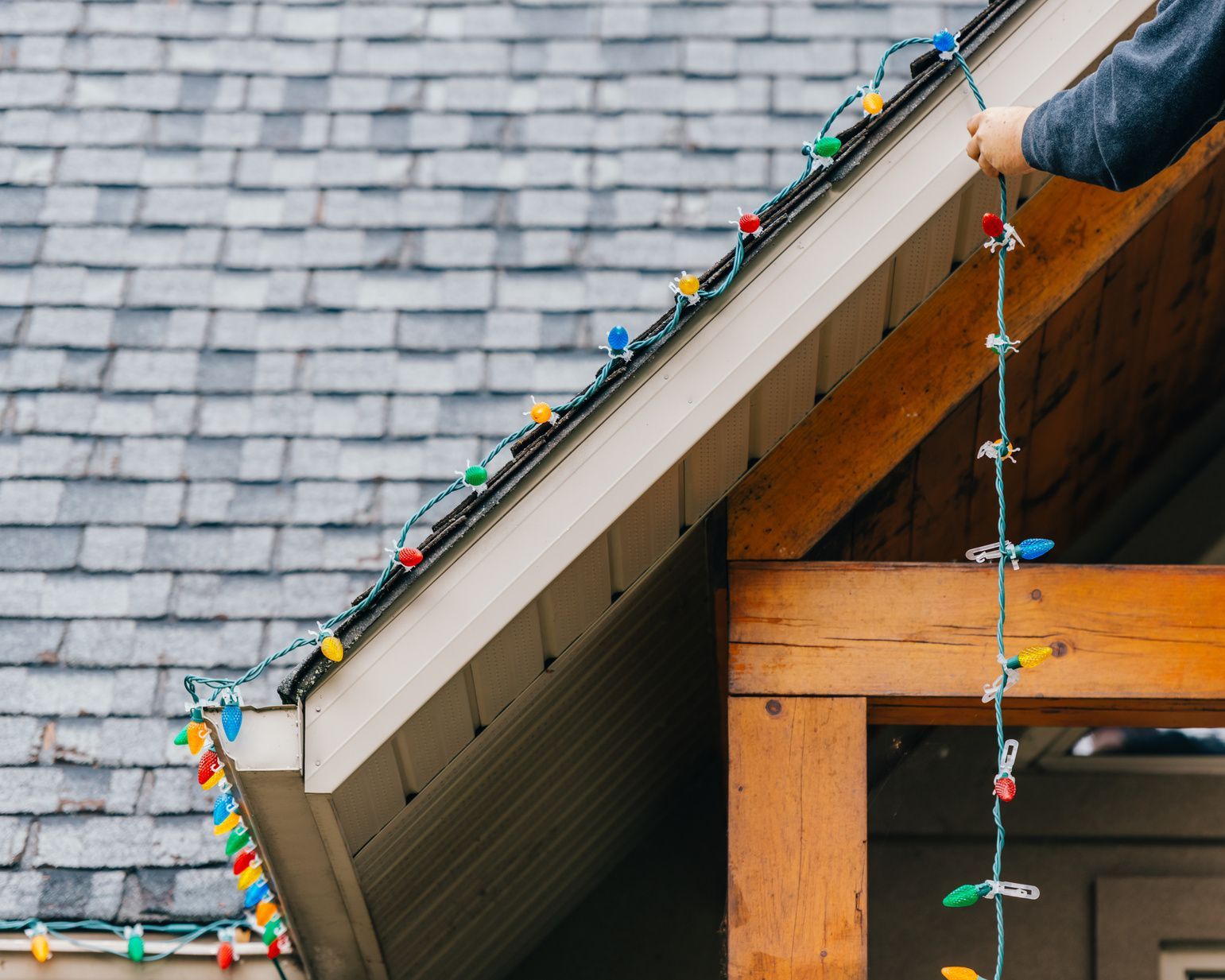 man installing christmas lights on pitch