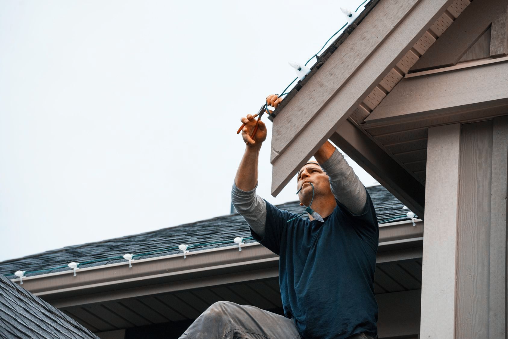 man installing christmas lights