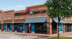 Children's Health Urgent Care clinic exterior with brick facade, awning, and signage on a sunny day.