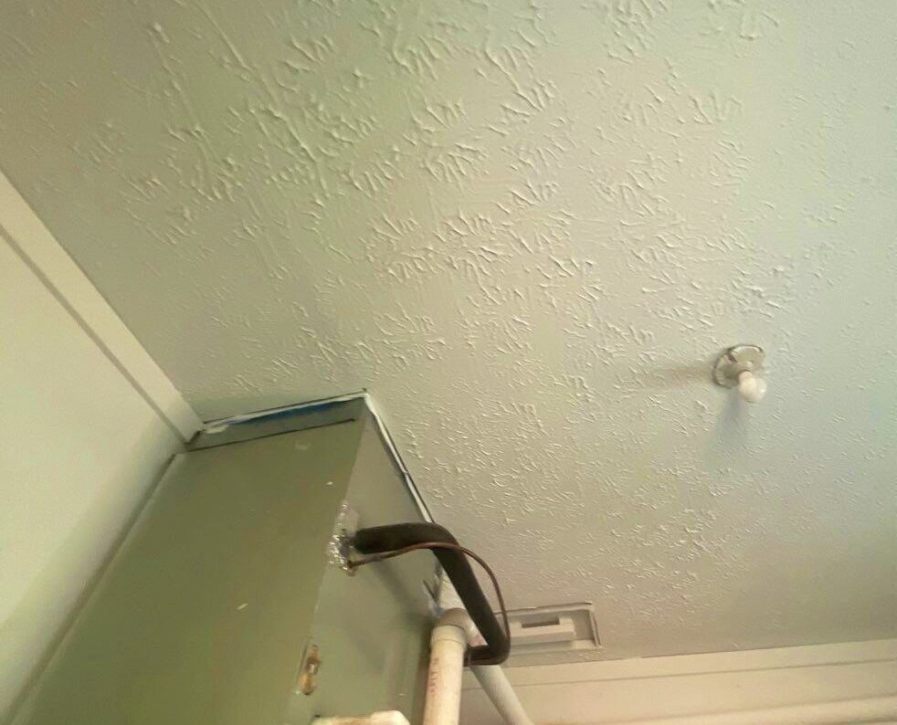 A ceiling with a box and pipes on it