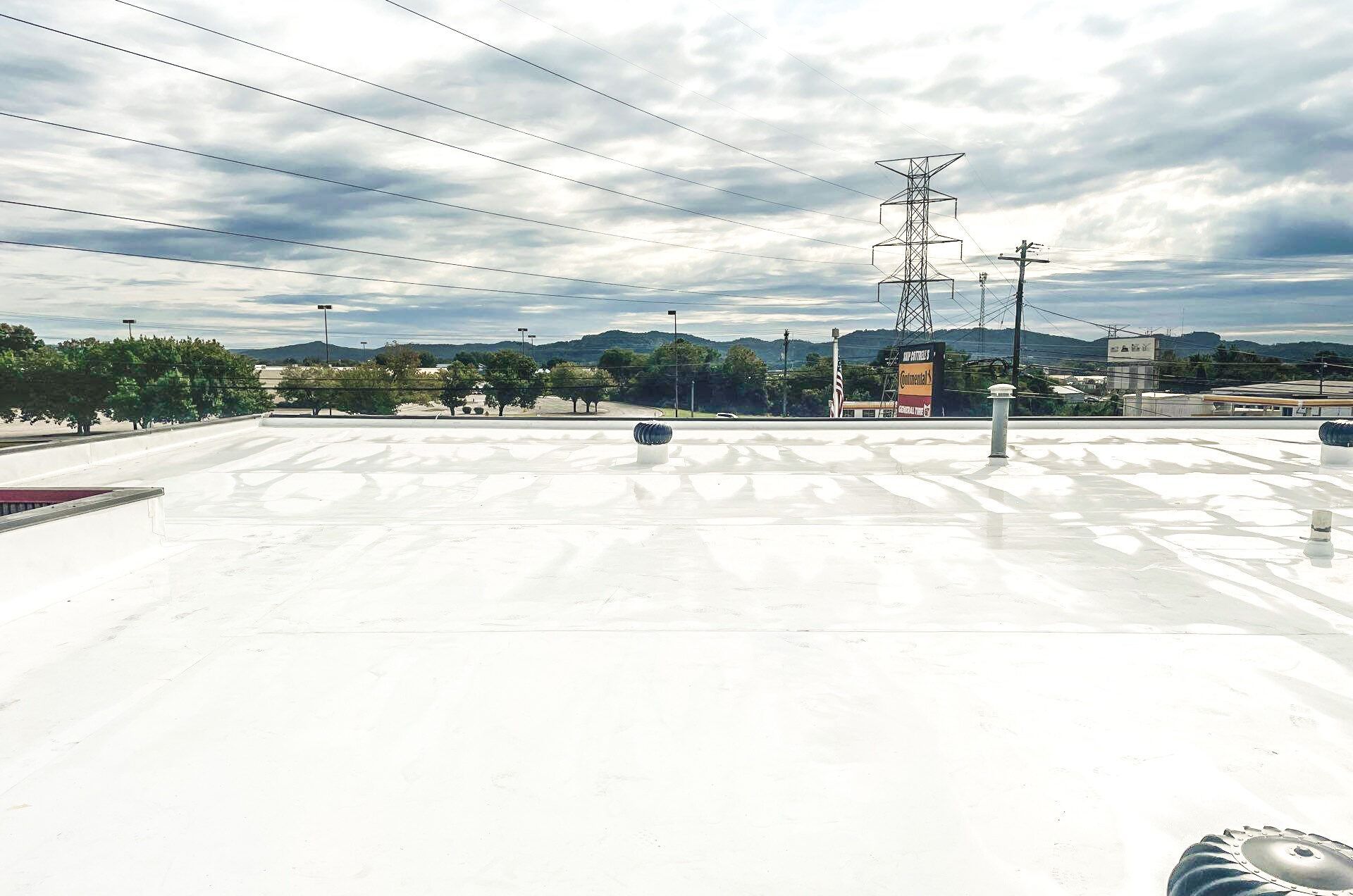 A white roof with a lot of power lines in the background