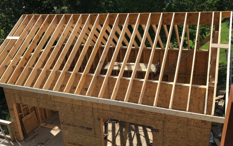 The roof of a building is being built with wooden beams
