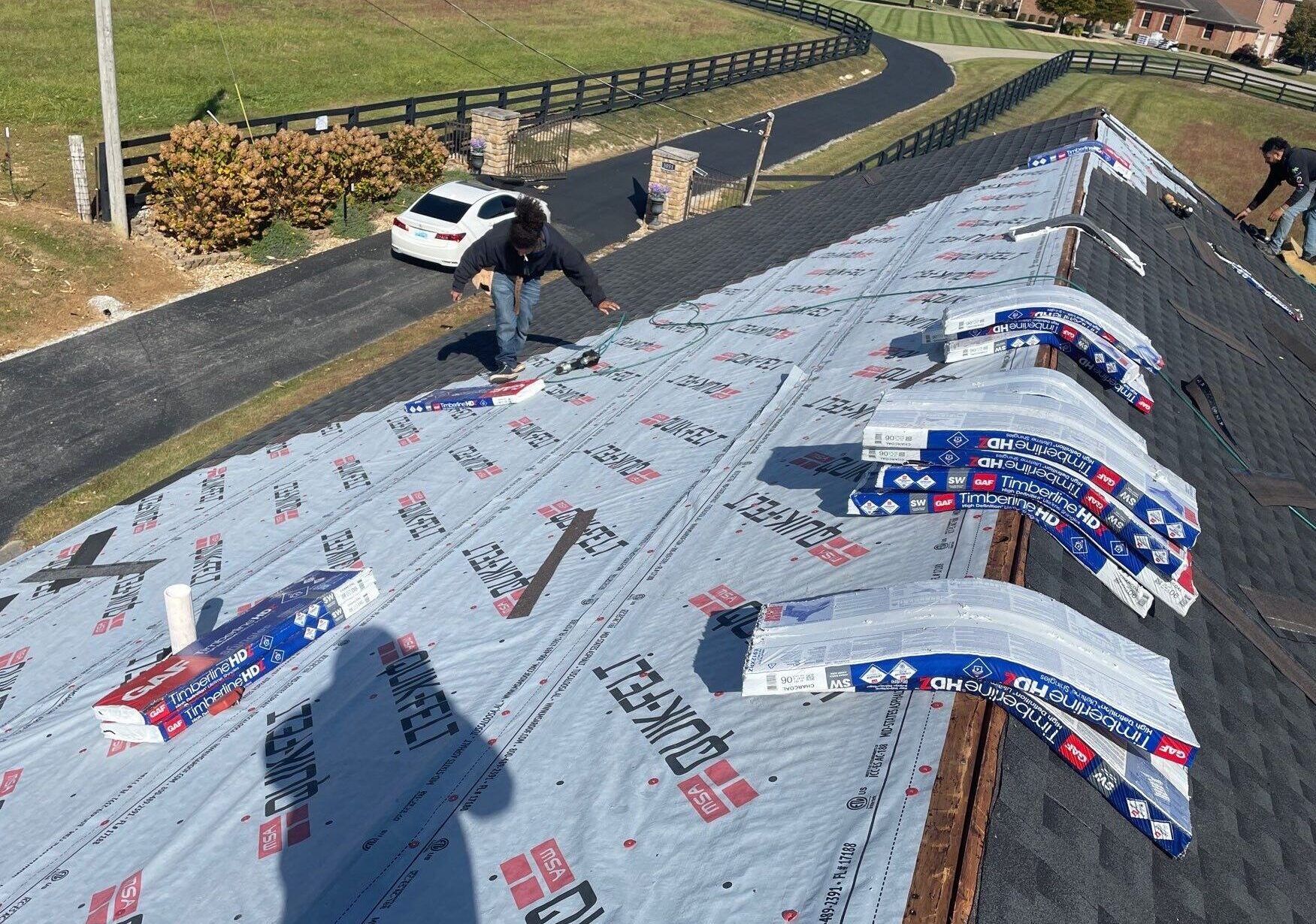 A man is working on the roof of a house.