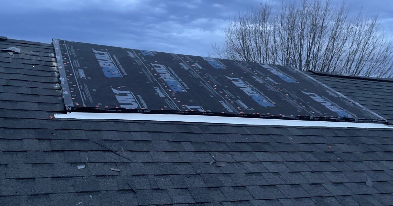 A close up of a roof with shingles being installed.