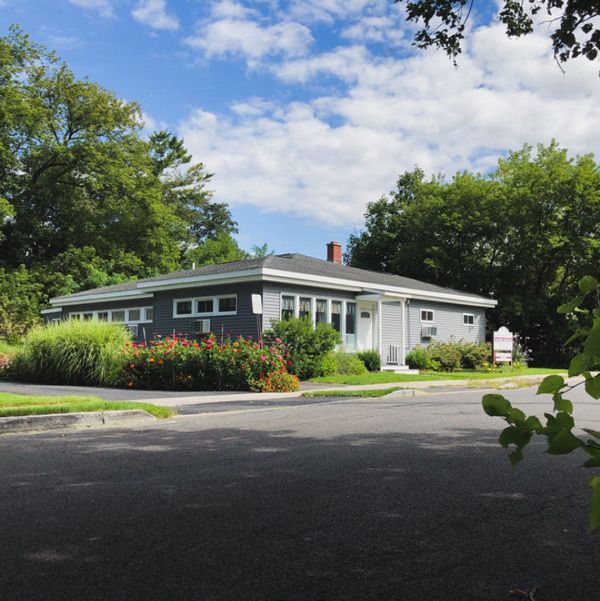 The front of a brick building with a sign that says cny tms psychiatry.