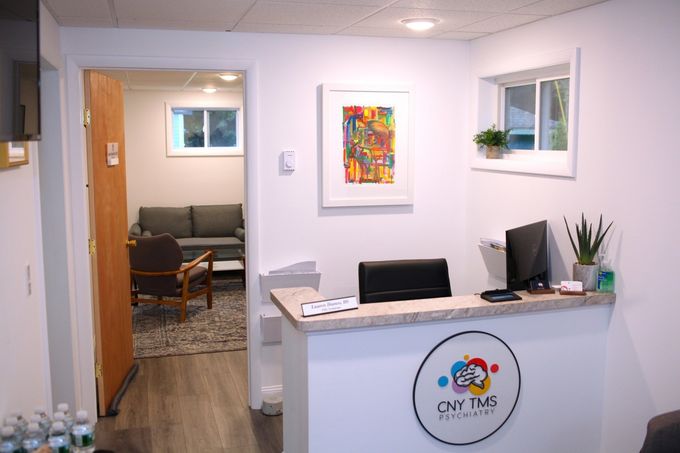 A reception desk in a room with a couch and chairs.