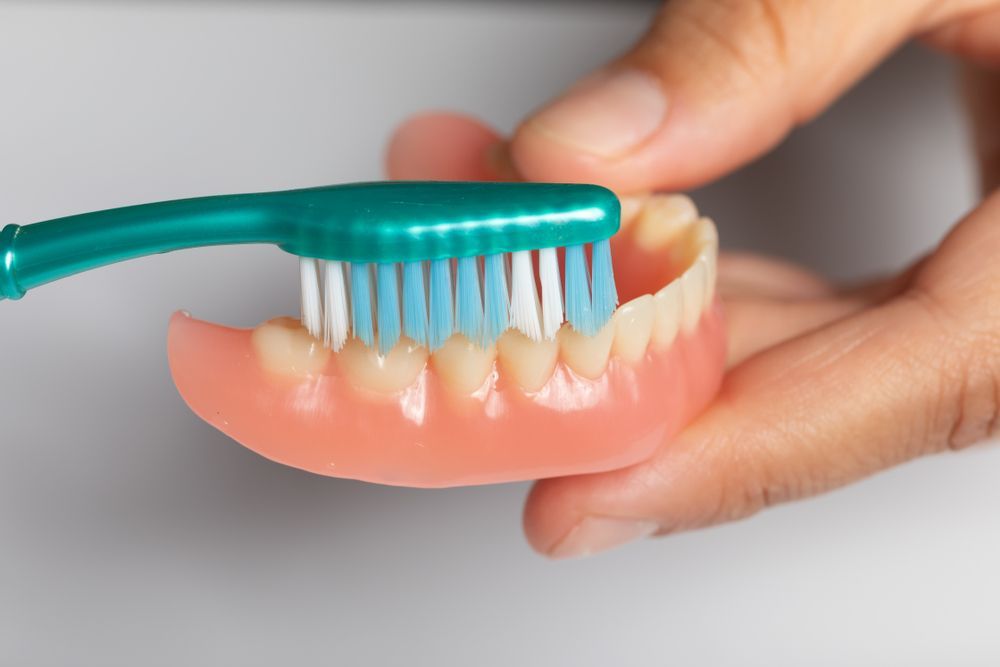 Cleaning The Dentures Using A Brush