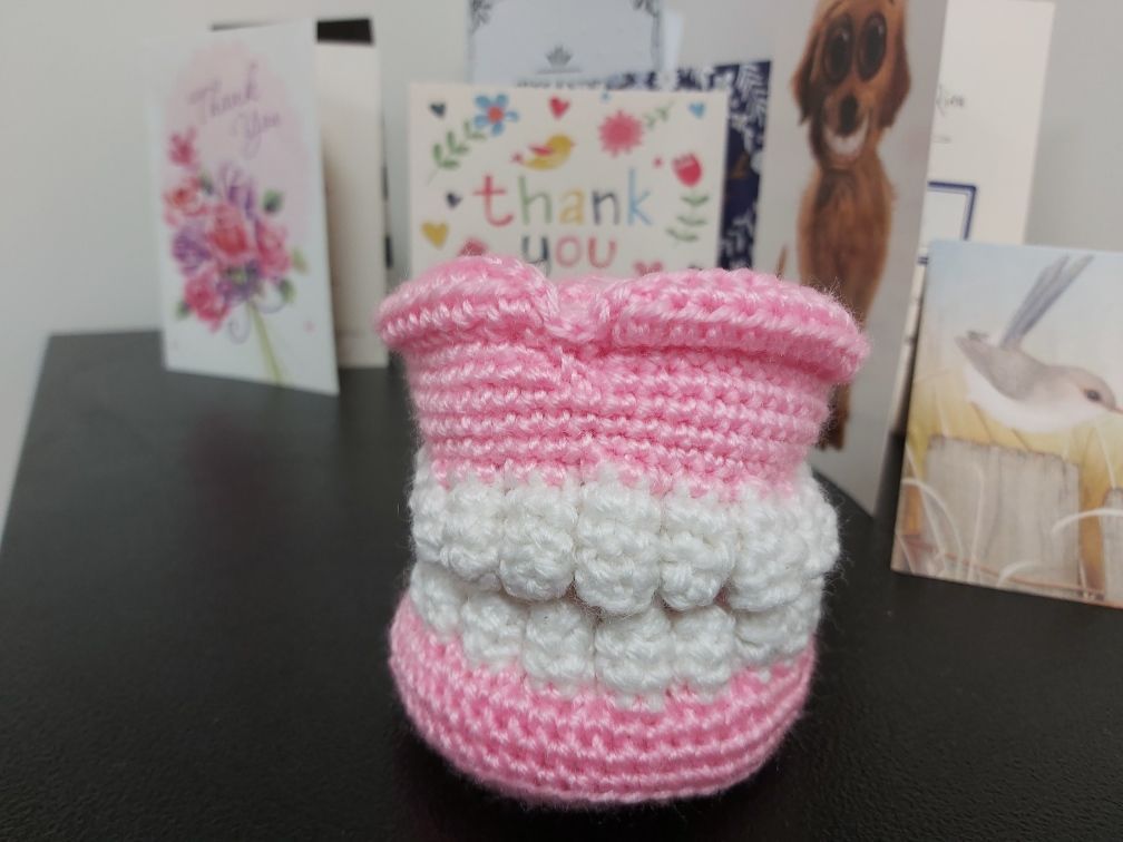 A Crocheted Teeth is on a Table Next to a Thank You Card — Complete Denture Clinic in Kanwal, NSW