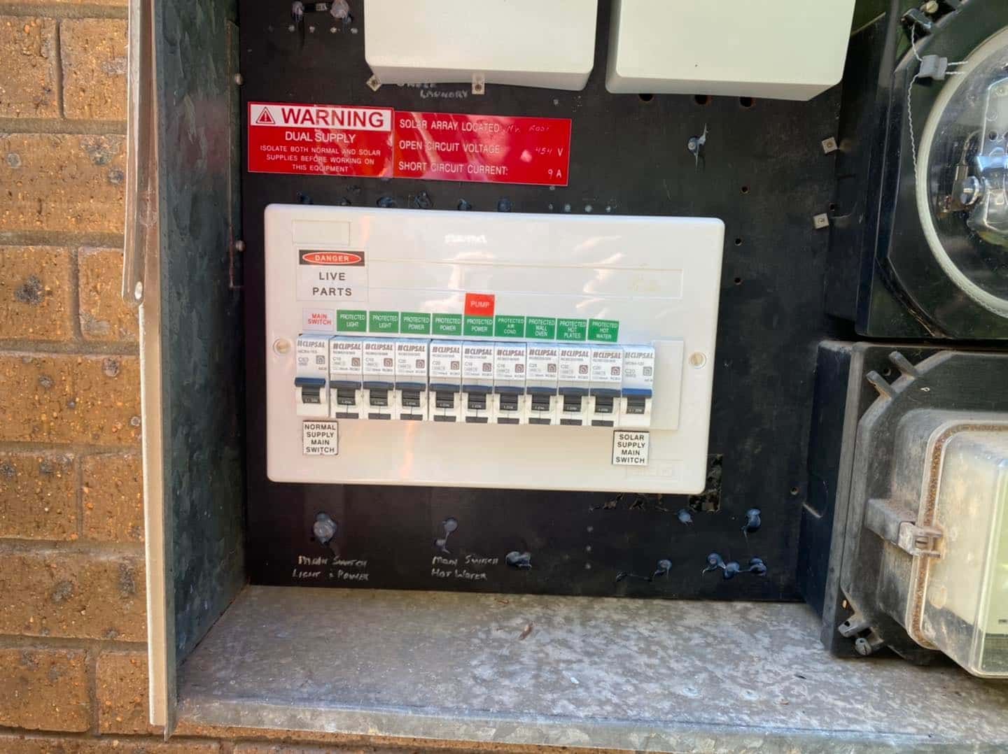Electrical Panel With Circuit Breakers Mounted on a Brick Wall — SparkSafe Electrical in Kiama, NSW