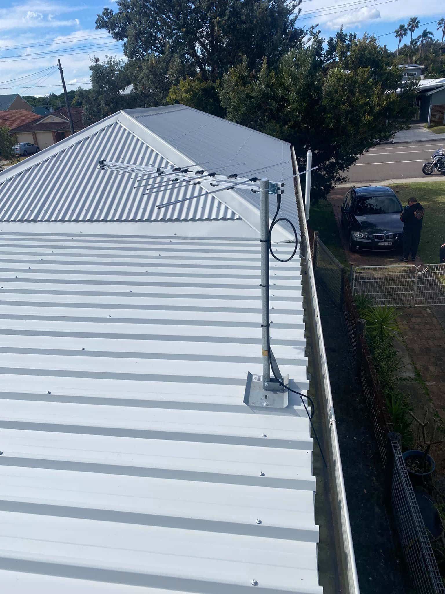 TV Antenna Mounted on a White Metal Roof Next to a Gutter — SparkSafe Electrical in Dapto, NSW