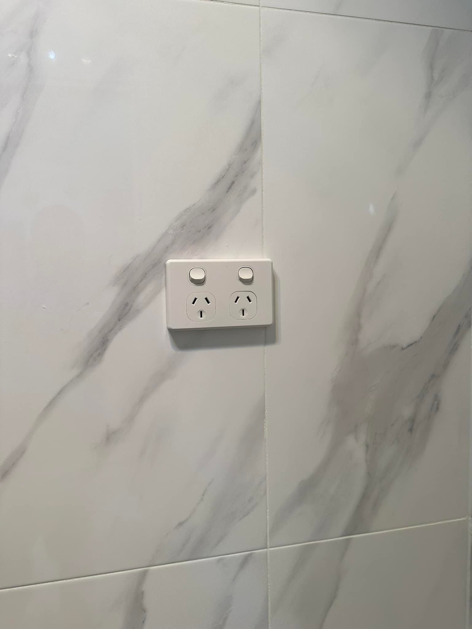 White Electrical Outlet on Marble-patterned Tile Wall — SparkSafe Electrical in Bulli, NSW