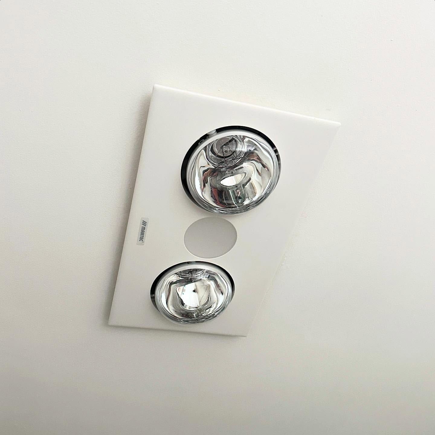 White Rectangular Bathroom Light Fixture With Two Heat Lamps and a Circular Vent — SparkSafe Electrical in Dapto, NSW