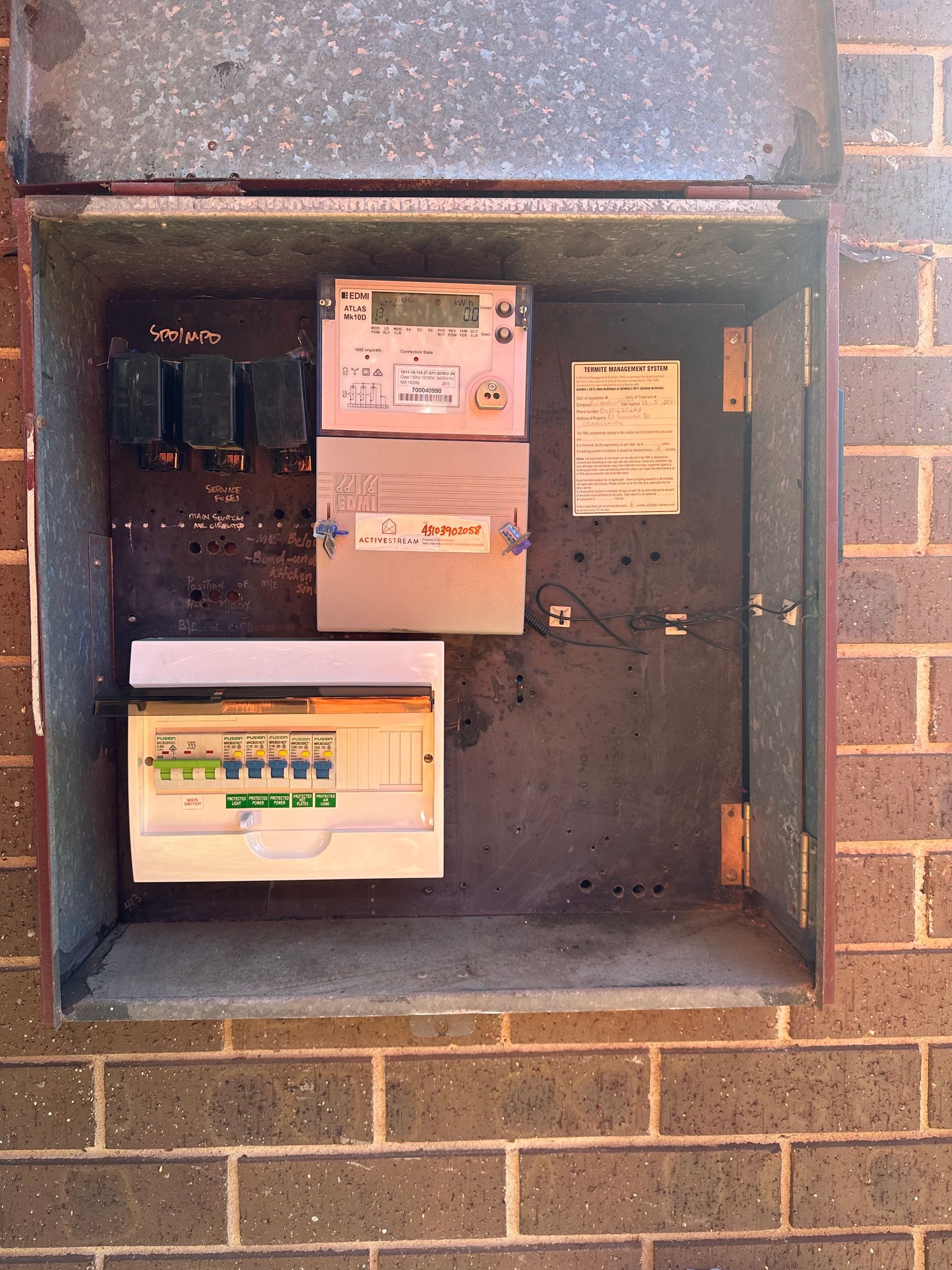 Electrical Panel With Switches and Fuses Mounted on a Brick Wall — SparkSafe Electrical in Dapto, NSW