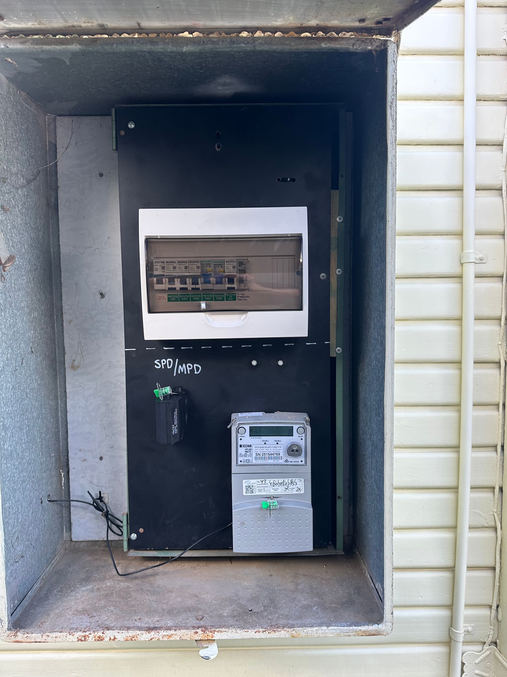 Electrical box with circuit breakers and a meter, mounted on a building's exterior  — SparkSafe Electrical in Dapto, NSW
