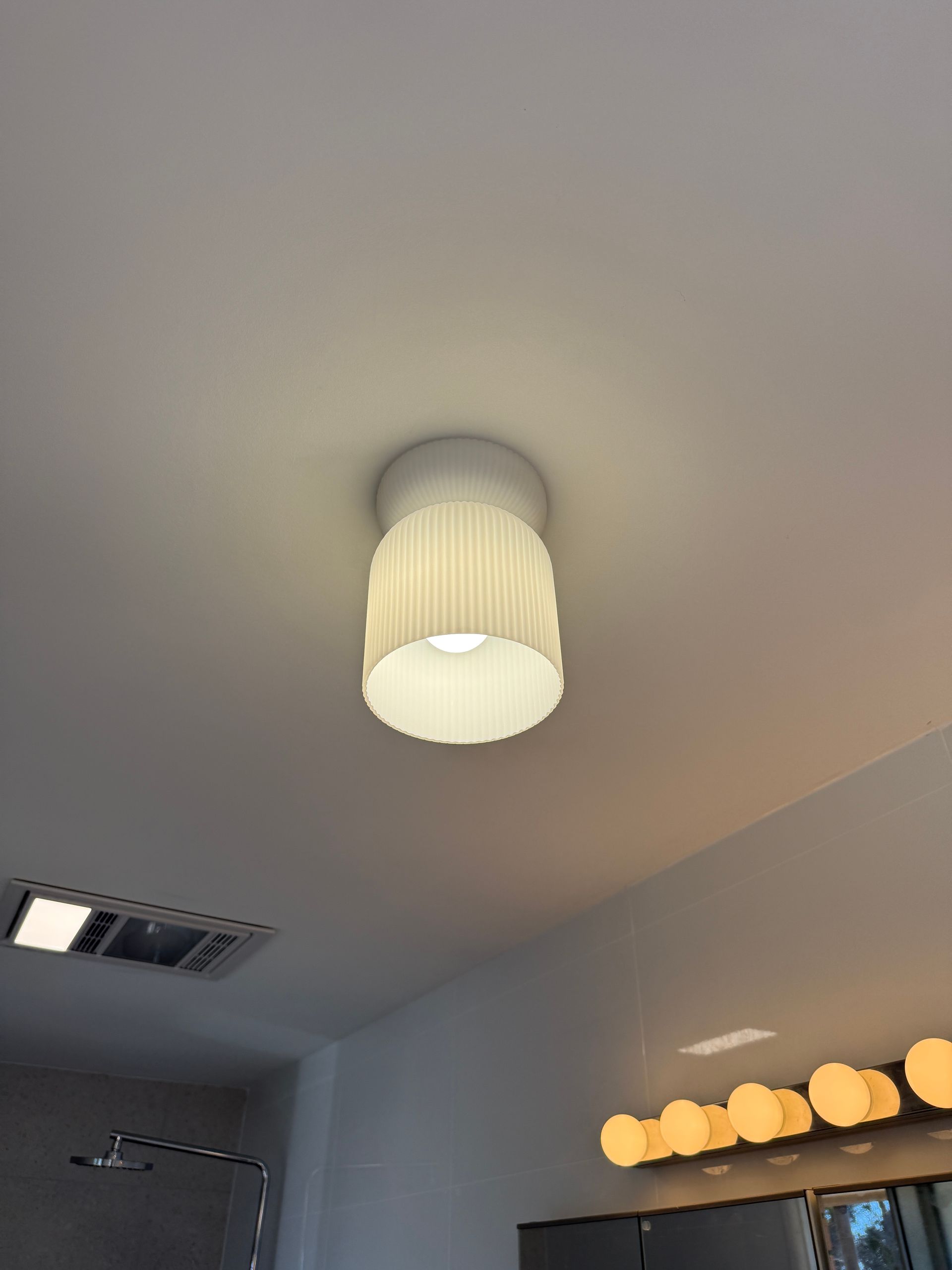 White ceiling light with a pleated shade in a bathroom  — SparkSafe Electrical in Dapto, NSW