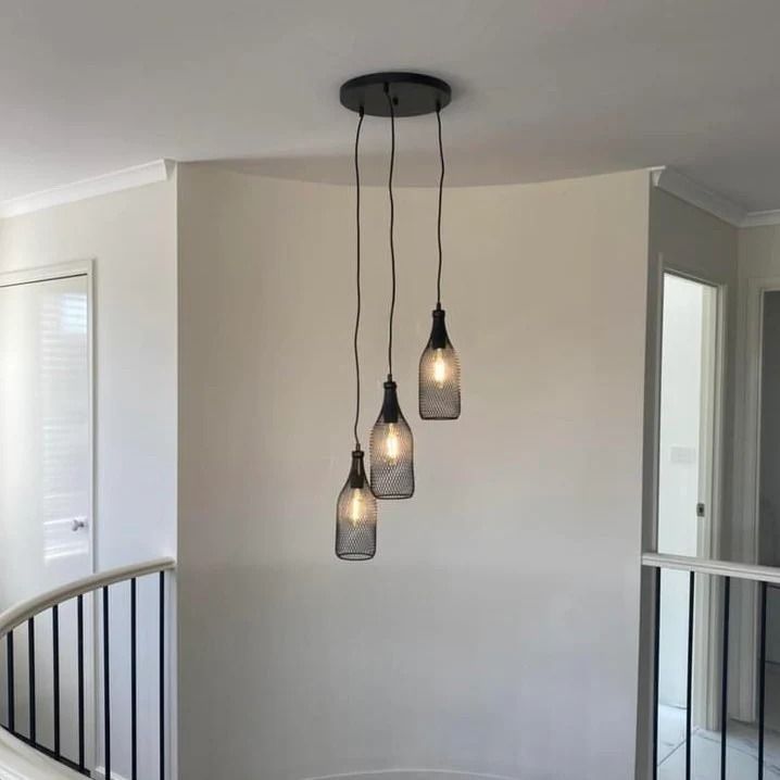 Three pendant lights, each shaped like a bottle, hang from a black ceiling plate in a home - SparkSafe Electrical in Dapto, NSW