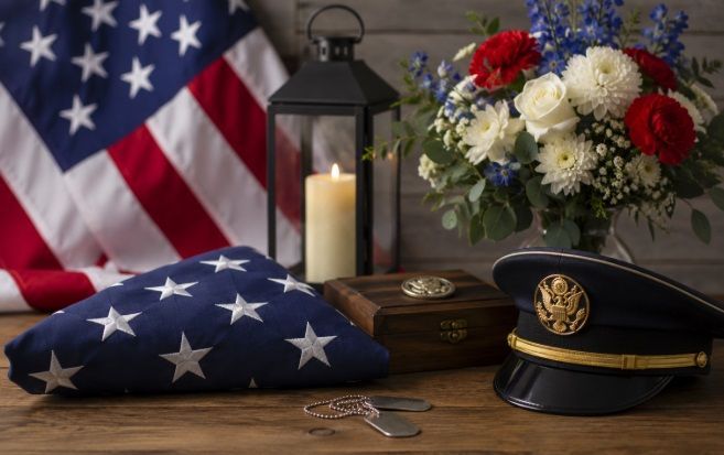 Military memorial display with a folded flag, flowers, candle, and service memorabilia for cremation service Kennebunk, ME