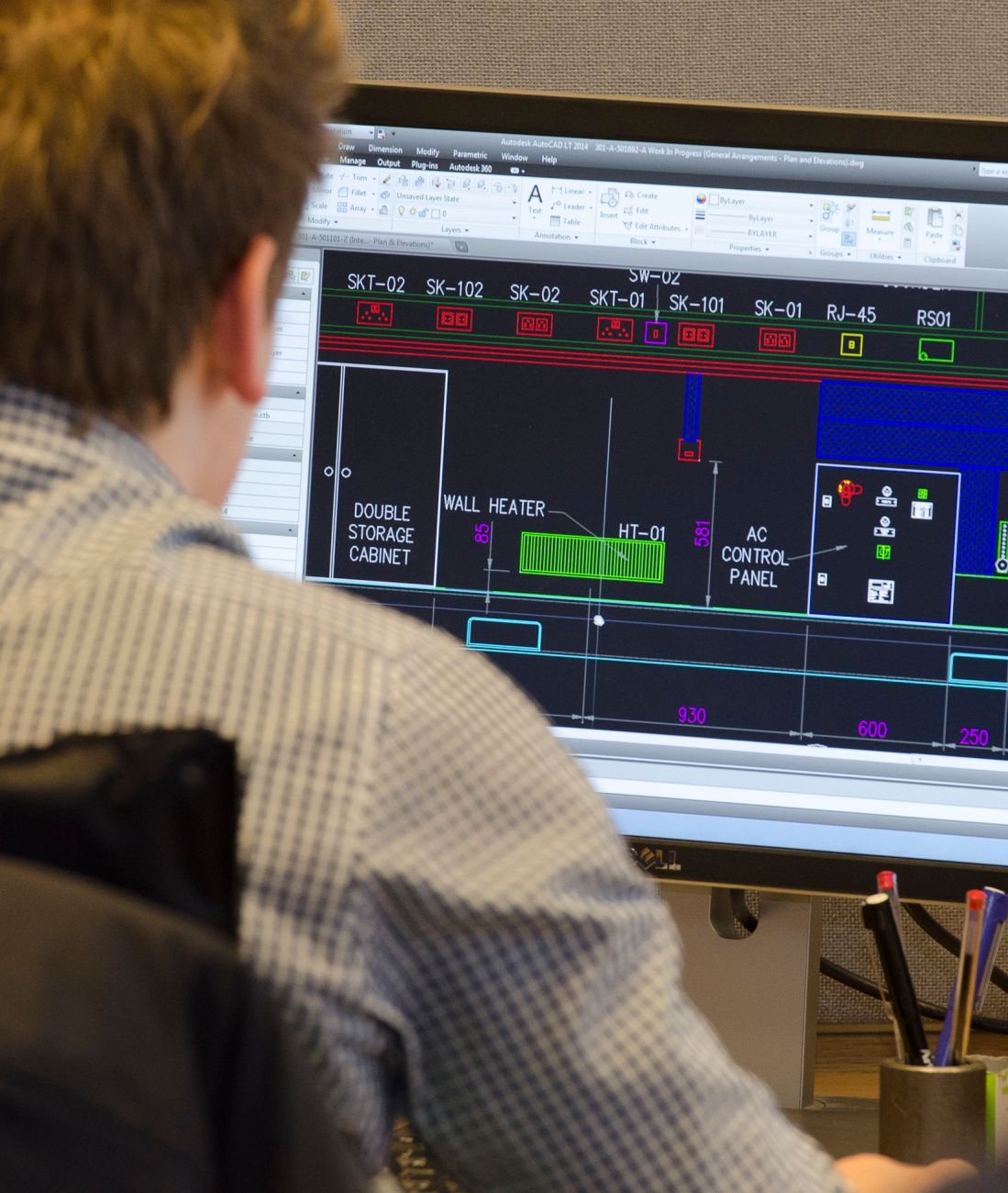Person looking at a computer screen displaying a technical diagram in an office setting.