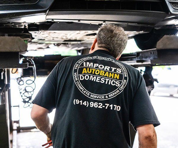 A man wearing a black shirt that says imports autobahn domestics