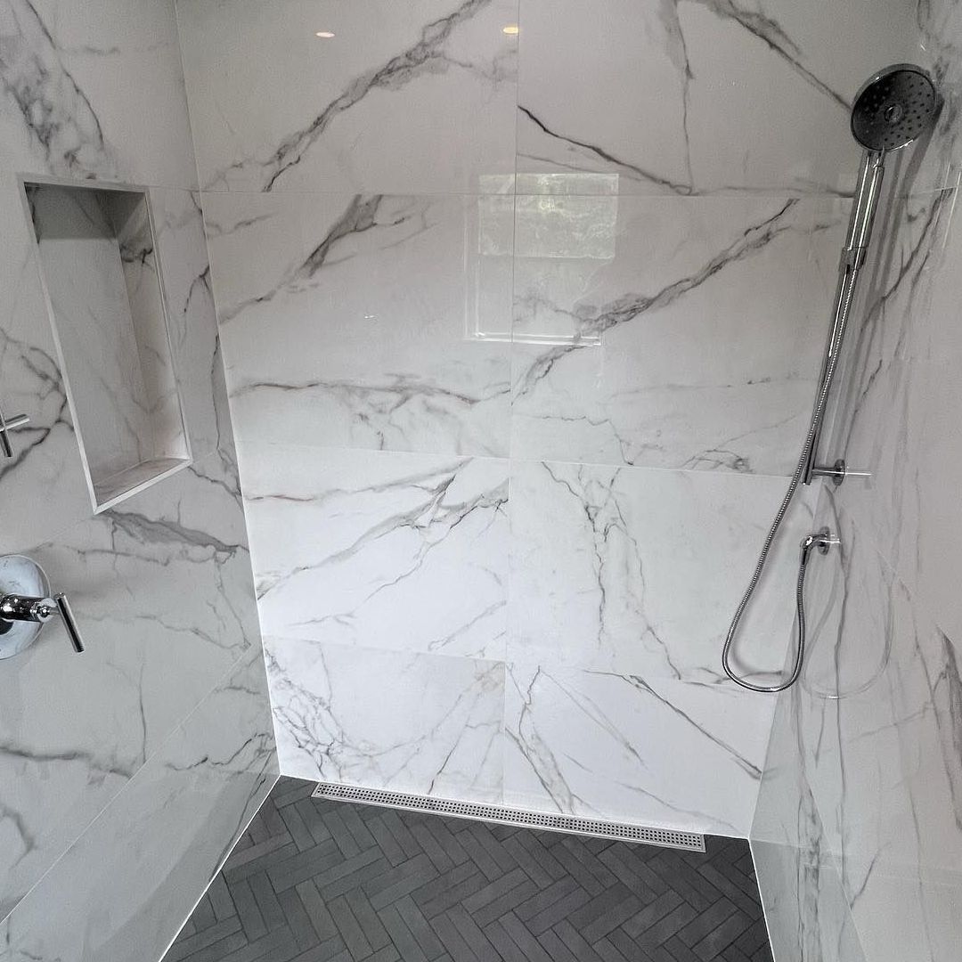 A shower with marble walls and a shower head