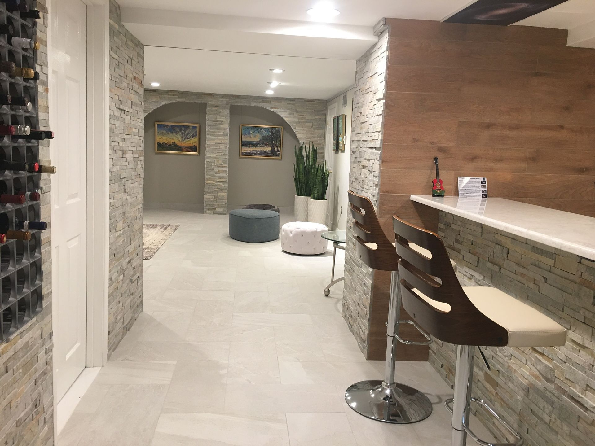 A hallway in a house with a bar and stools