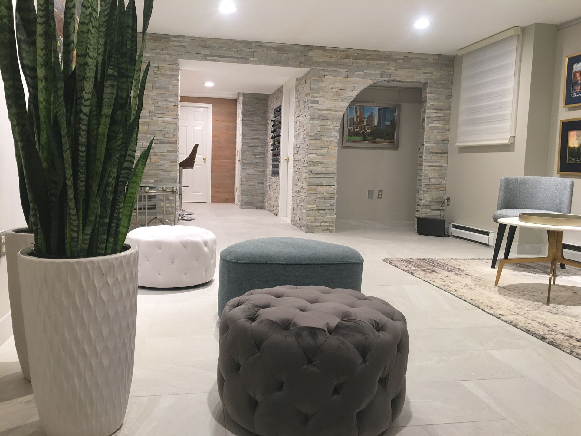 A living room with ottomans and a potted plant.