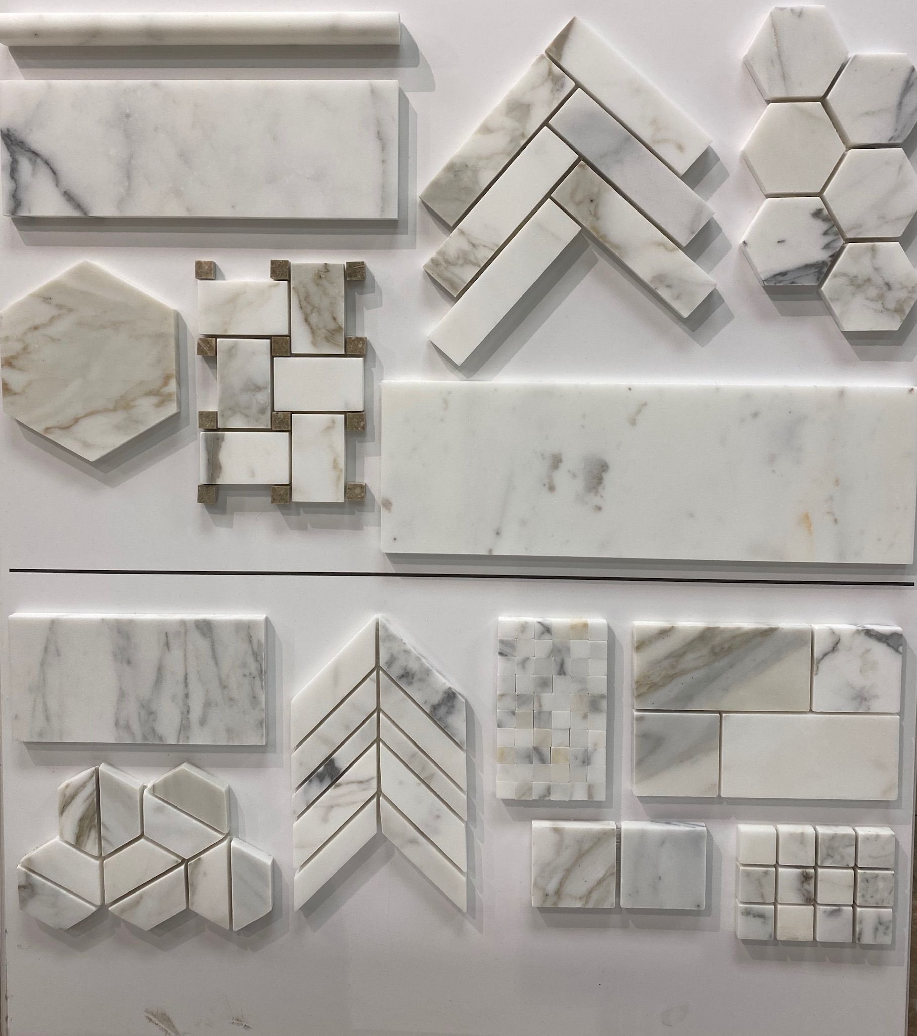 A variety of marble tiles are displayed on a white surface