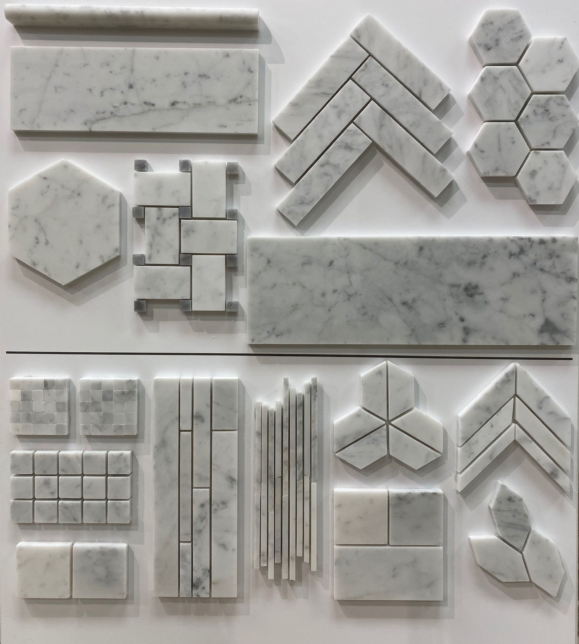 A variety of marble tiles are displayed on a white surface.